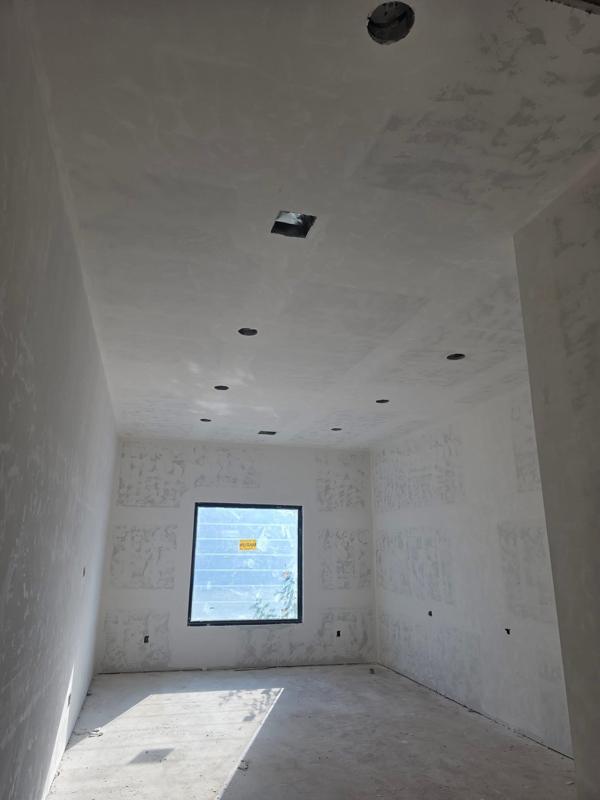 Finished drywall in a bedroom with a view of the lot