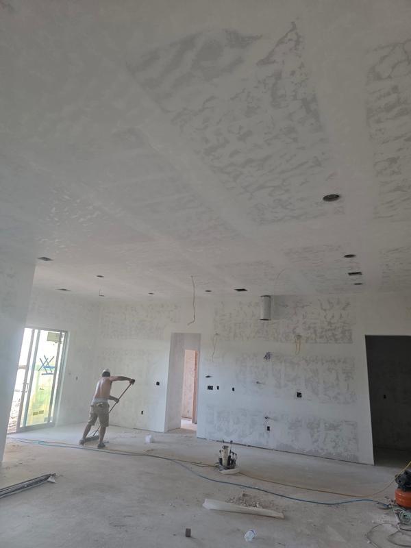 Crew finishing drywall in an open living room