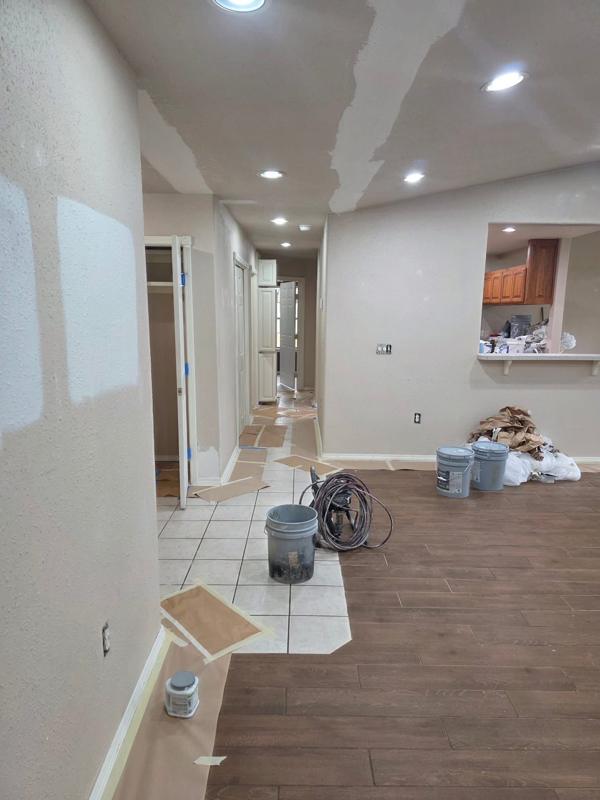 Hallway with new plank flooring meeting new tile